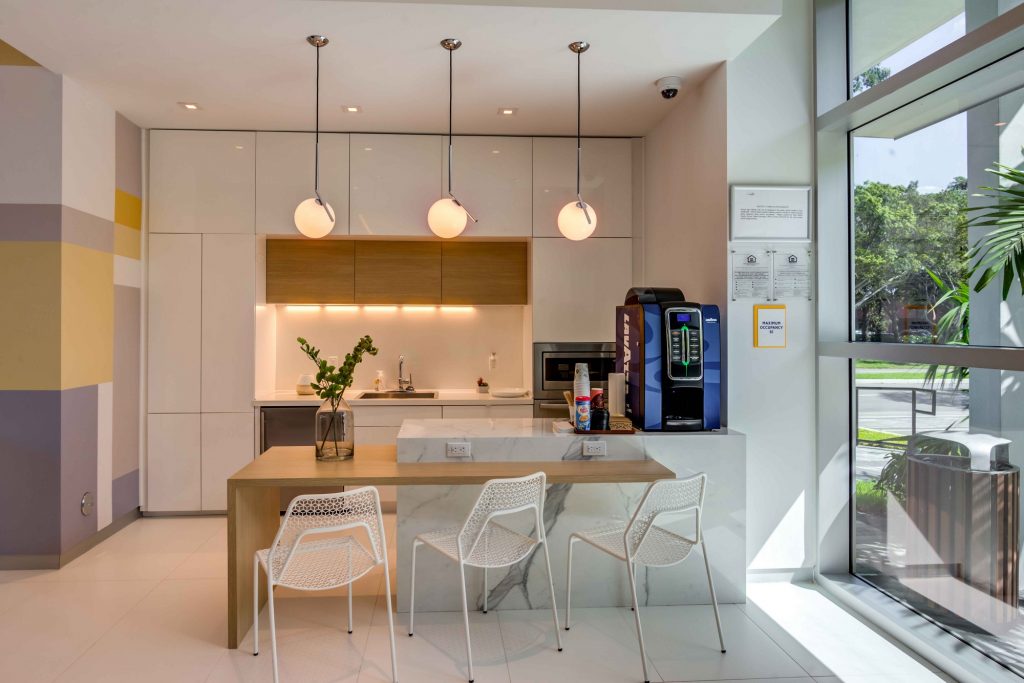 coffee bar with overhead lighting, kitchen, and bar area with seating