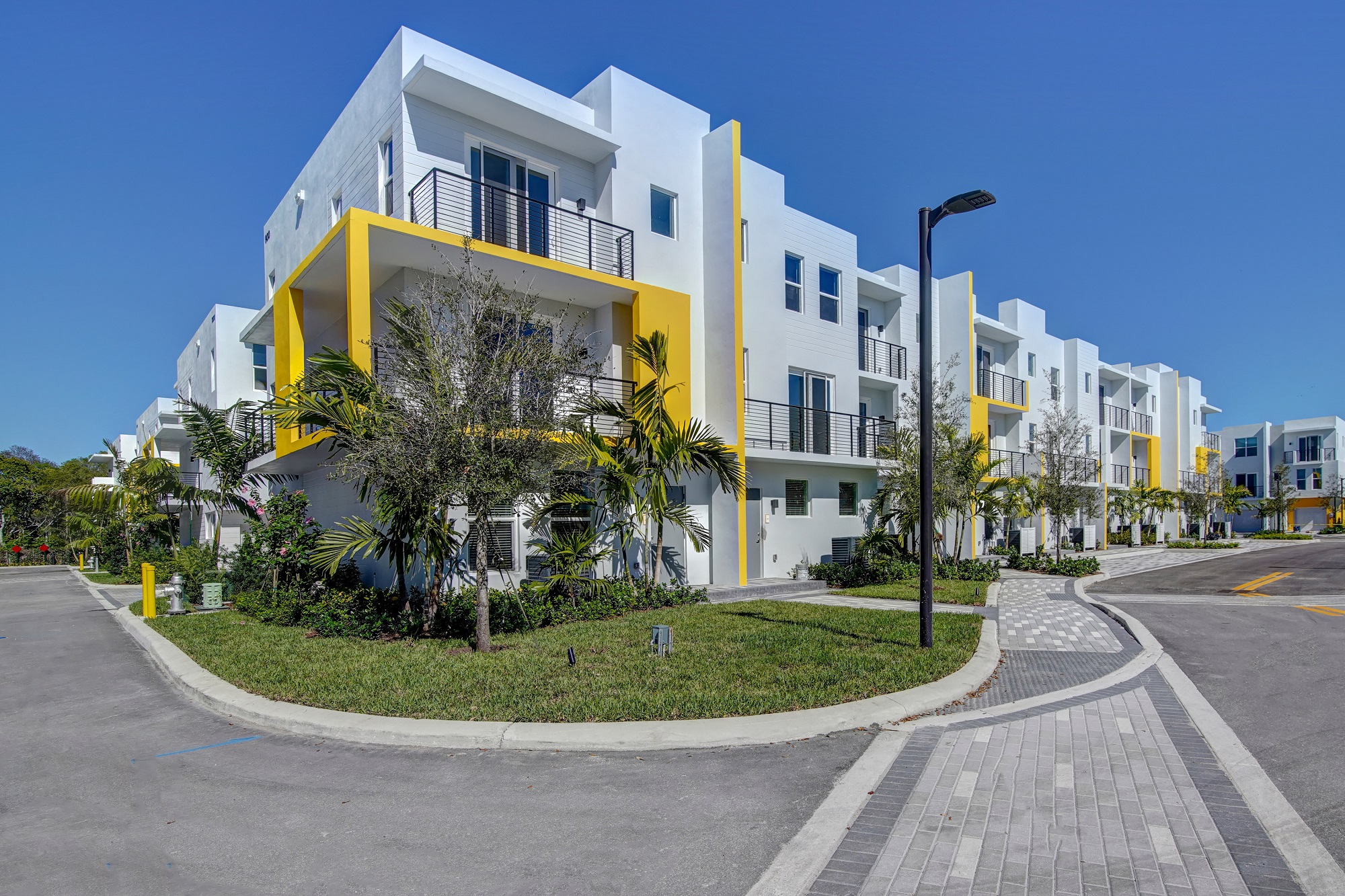 view from a corner of the building with palm tree landscaping