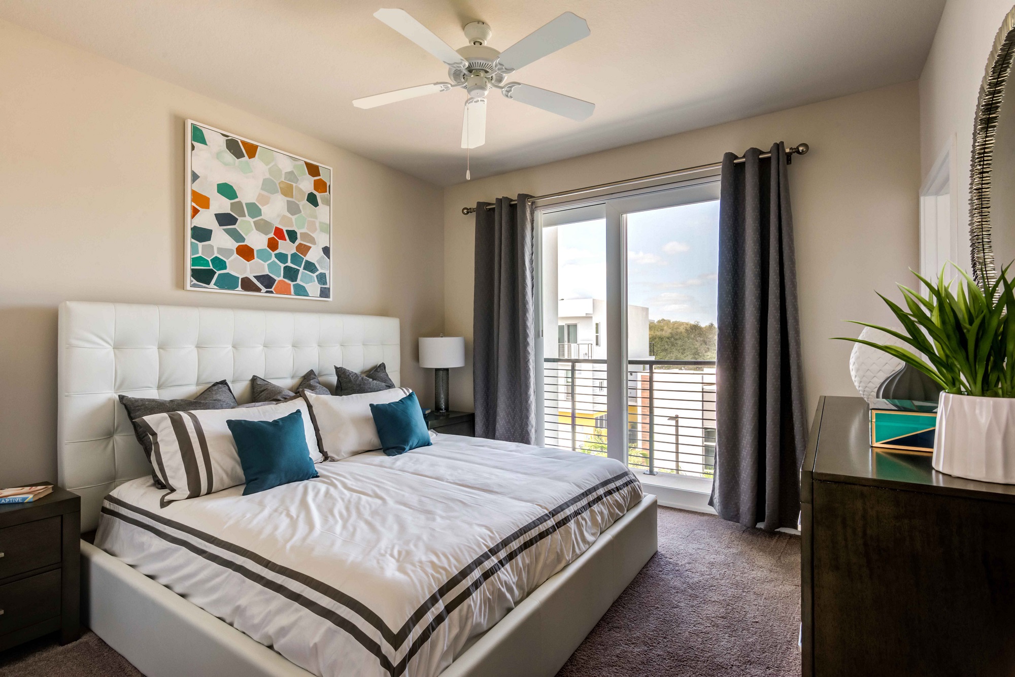 Bedroom area with window, ceiling fan, wall paintings, and carpet flooring