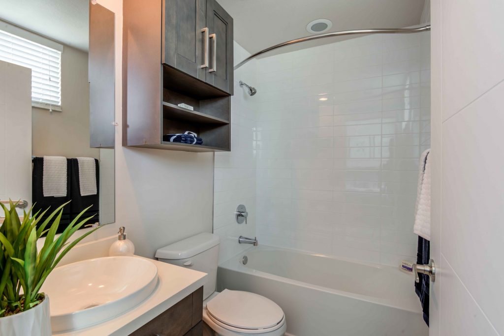 Bathroom with mirror, sink, toilet, and tub/shower